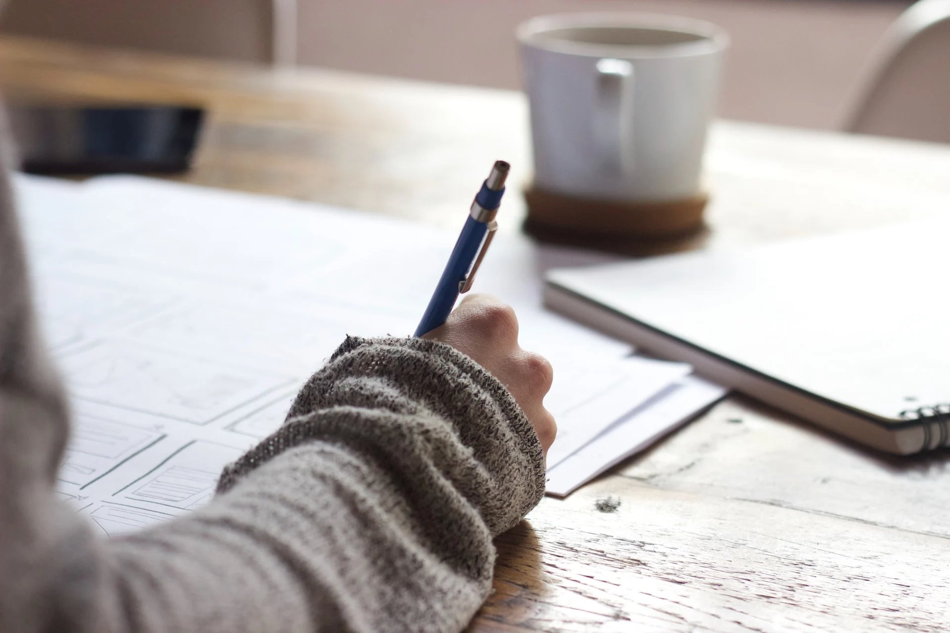 Person writing notes of a piece of paper. 