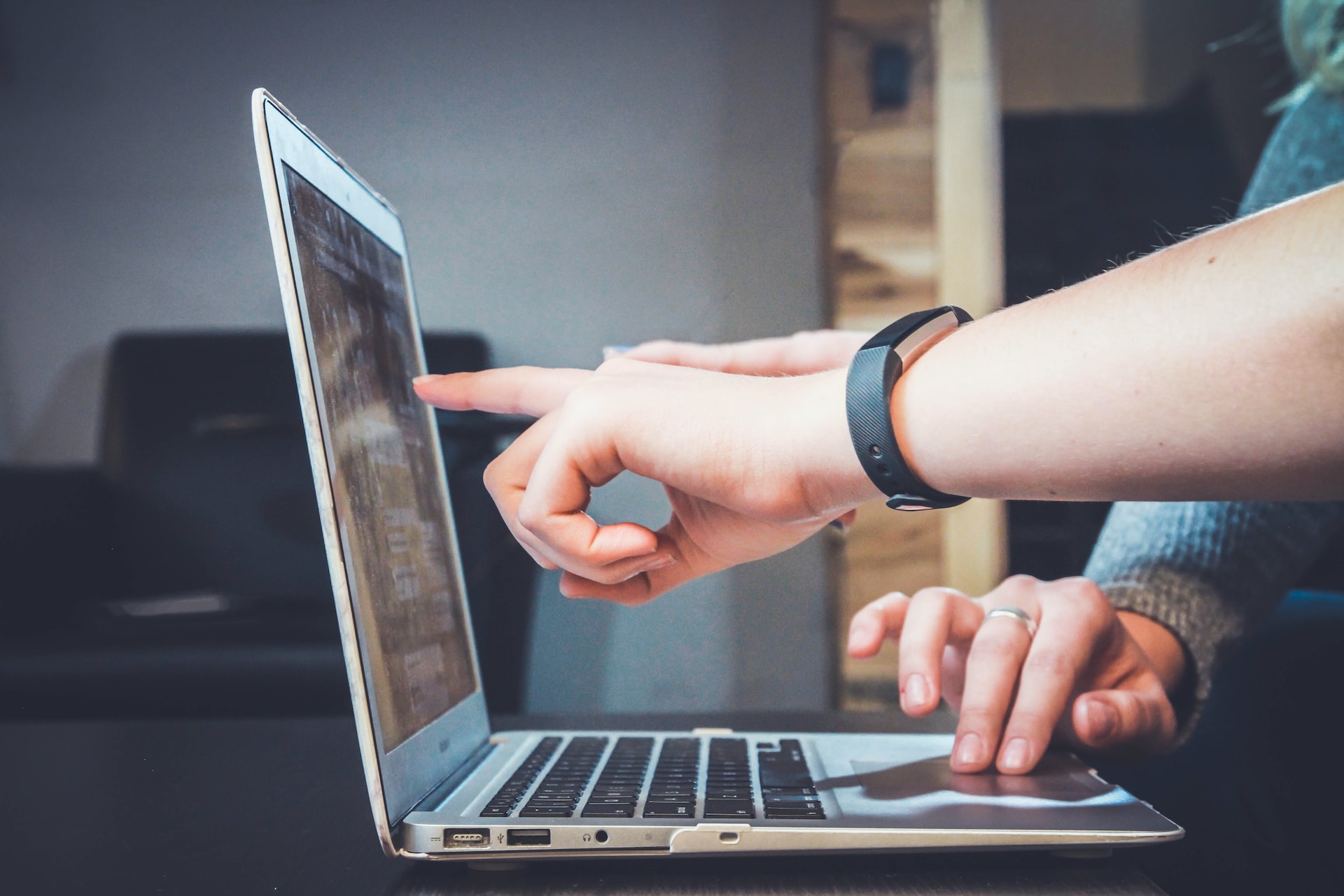 close up of fingers pointing at a laptop screen