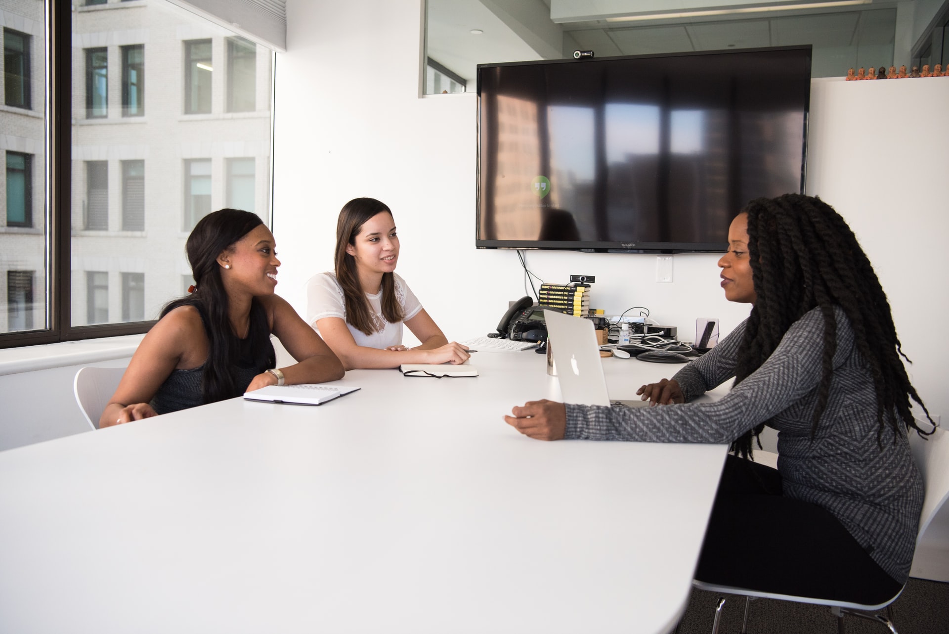 three people chatting at a white table